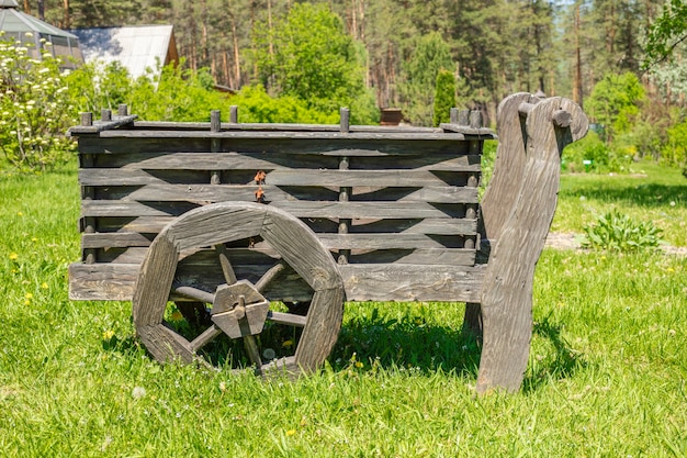 Vieux chariot en bois sur un pré vert