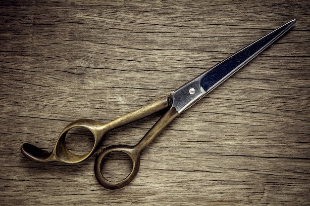 Vieux ciseaux de coiffure sur fond de bois