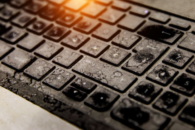 Vieux clavier noir sale avec de la poussière et des taches.