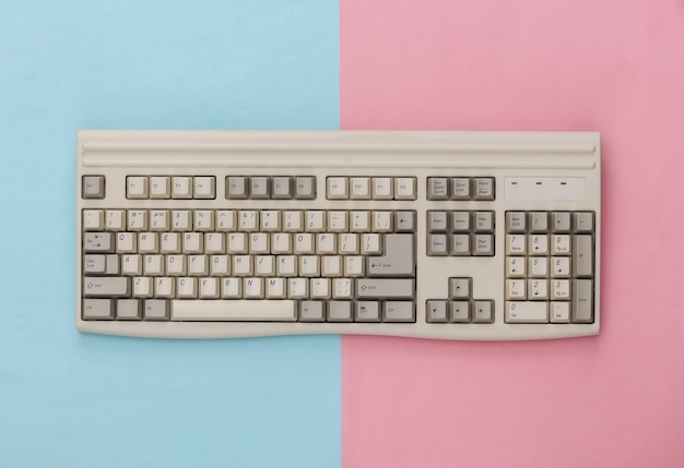 Photo vieux clavier pc sur fond rose bleu. vue de dessus. mise à plat
