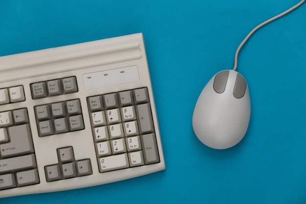 Vieux clavier et souris pc sur fond bleu. Vue de dessus. Mise à plat