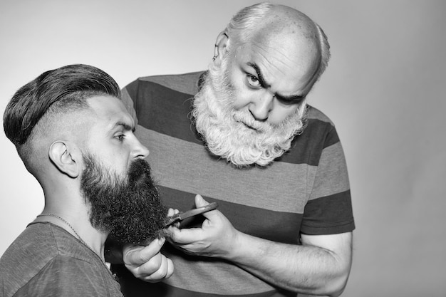 Vieux coiffeur et jeune homme barbu