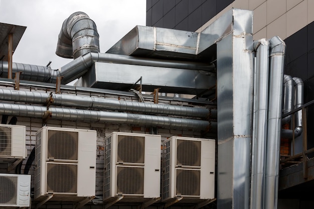 Vieux conduits d'air de ventilation extérieurs et climatiseurs à l'extérieur du mur arrière de la cuisine du café