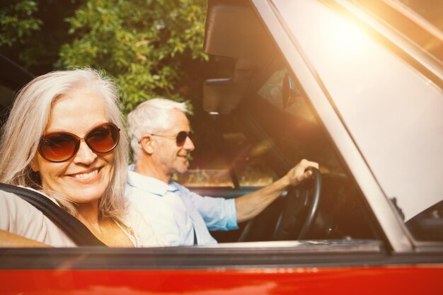 Vieux couple dans une voiture souriant à la caméra