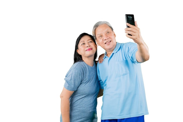 Vieux couple romantique prenant une photo de selfie en studio