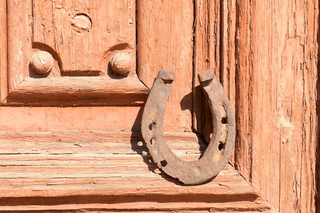 Vieux fer à cheval sur une porte en bois vintage à l'extérieur