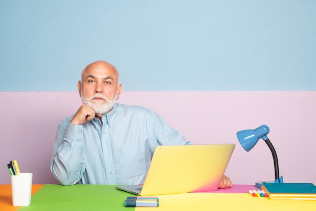 Vieux hommes d'affaires utilisant un ordinateur portable lors d'une réunion avec un ancien directeur ayant une conversation amicale lors d'une réunion avec l