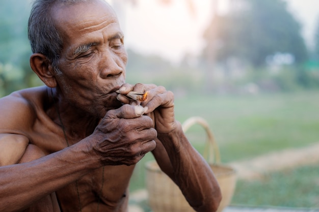 Les vieux hommes fument des cigarettes.