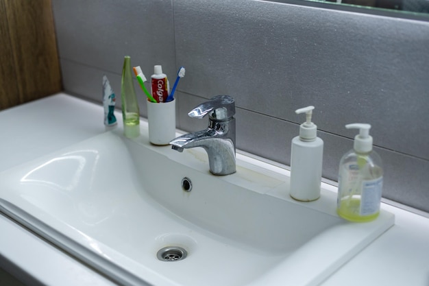 Vieux lavabo sale avec taches de rouille, taches de calcaire et de savon dans la salle de bain avec robinet, robinet d'eau.
