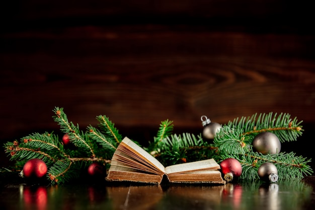 Vieux livre et boules de Noël sur table en bois