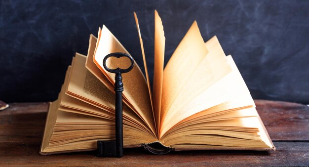 Vieux livre et une clé sur un bureau en bois