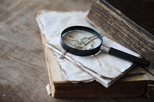 Vieux livres sur une table en bois et une loupe en verre