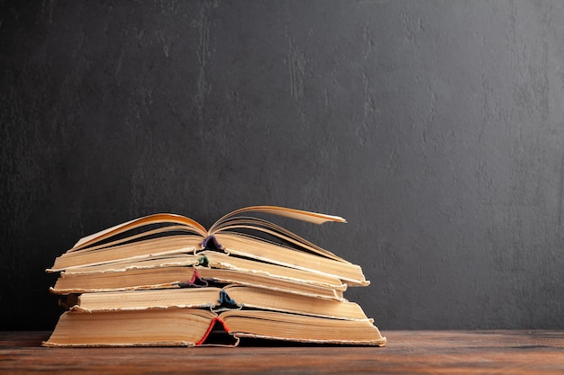 Vieux livres sur table en bois et tableau noir