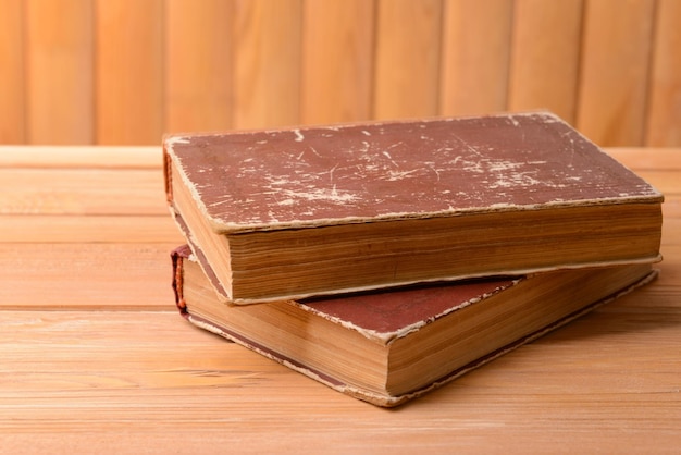 Vieux livres sur table sur fond de bois