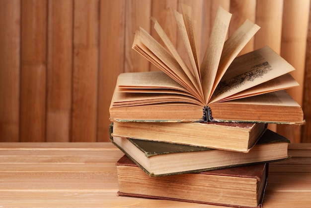 Vieux livres sur table sur fond de bois