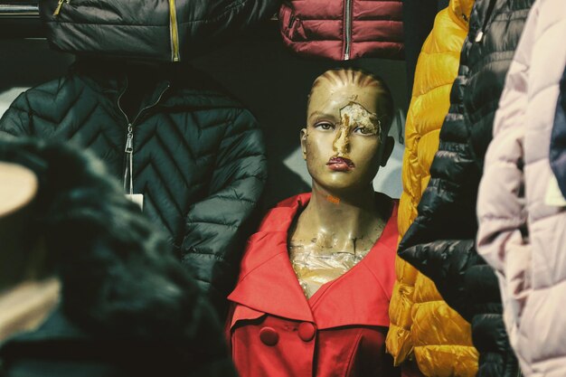 Photo vieux mannequin usé portant une veste rouge par des manteaux d'hiver dans le magasin