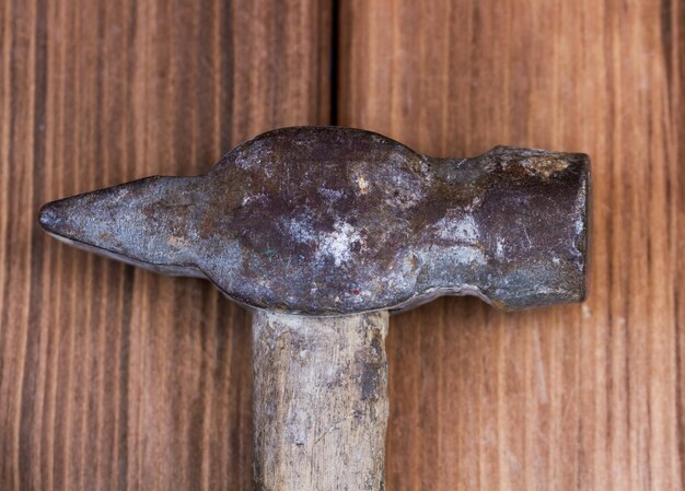 Vieux marteau sur fond de bois