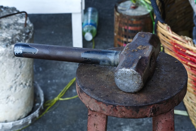 Vieux marteau en métal rouillé sur la chaise