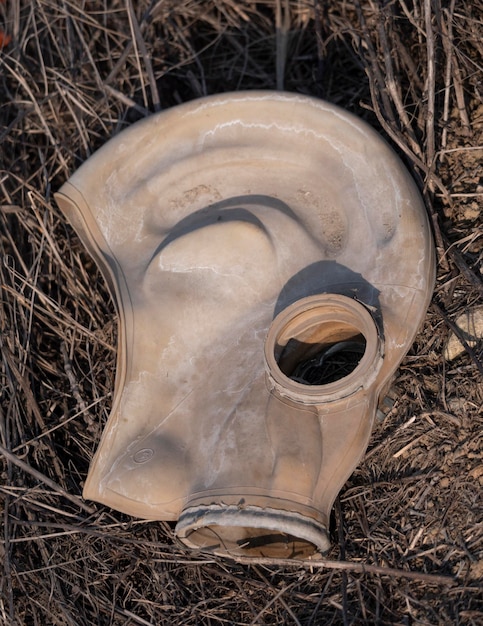 Un vieux masque à gaz se trouve dans un champ au sol