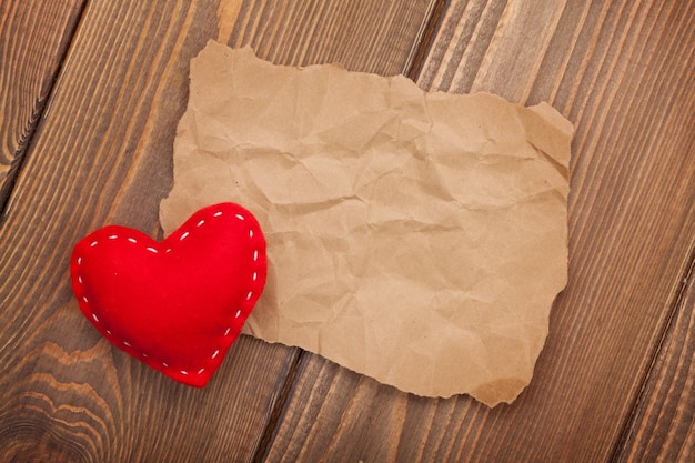 Photo vieux morceau de papier vierge et coeur de jouet de saint valentin fait à la main vintage