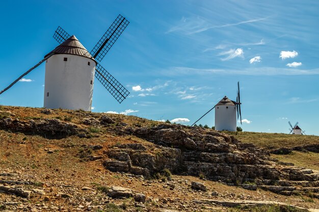 Vieux moulins à vent blancs, en pierre, sur le terrain avec ciel bleu et nuages blancs. La Mancha, Castille, Espagne. L'Europe .