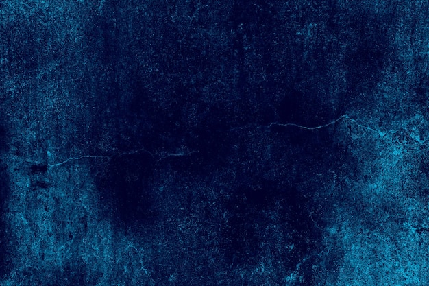 Vieux mur de béton fissuré de couleur bleu foncé avec une texture grunge lourde pour le fond