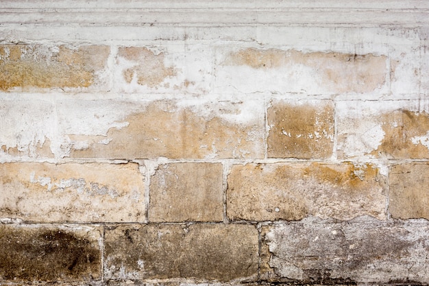 Le vieux mur de blocs avec des fissures et des copeaux. Contexte.