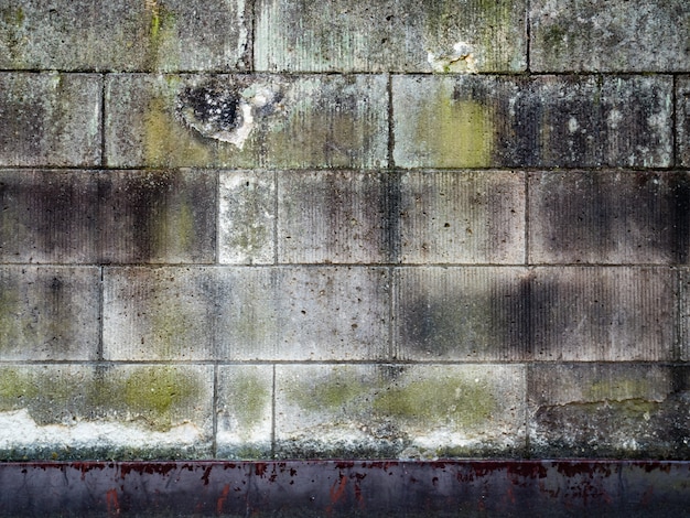 Vieux mur de briques en béton fissuré