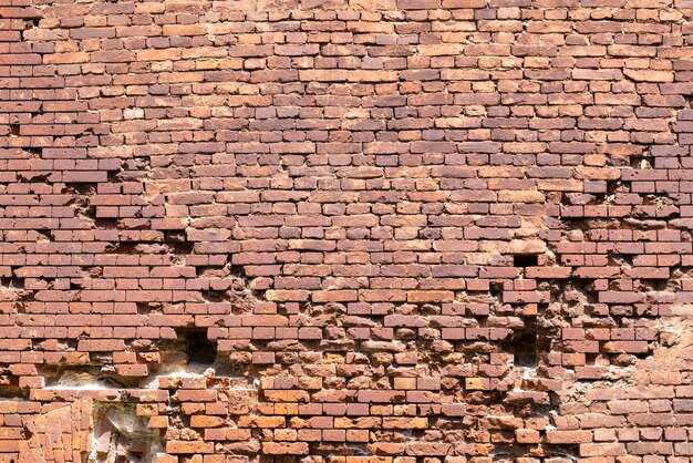 Un vieux mur de briques avec divers dommages