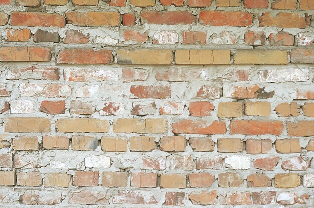 Vieux mur de briques rouges avec fond de peinture blanche