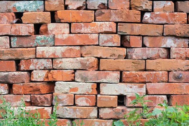 Photo un vieux mur de briques rugueuses avec une texture horizontale. le fond est fait d'un mur de briques. papier peint avec un mur de pierre. un mur dans le style retro grunge. mur de briques en briques rouges et anciennes