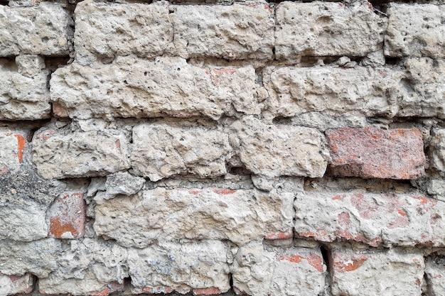 vieux mur de briques sous une couche de plâtre