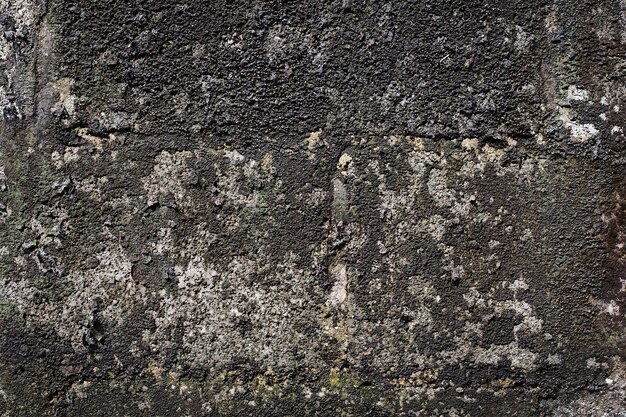 Vieux mur de ciment gris avec des fissures à la surface