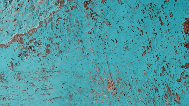 Vieux mur de ciment turquoise avec des fissures