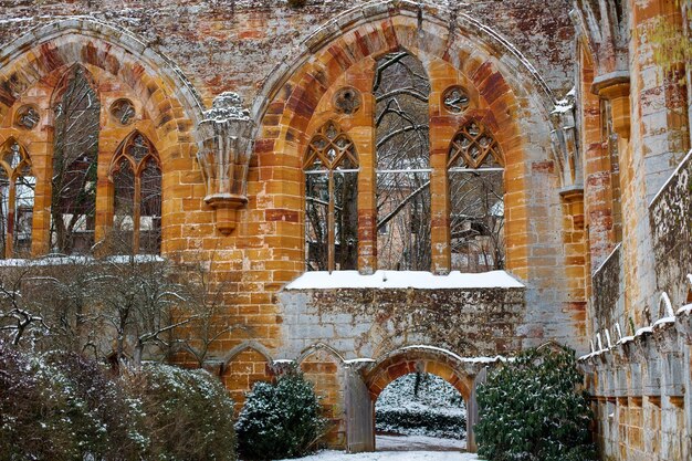 Vieux mur d'église en pierre rouge abandonné en hiver