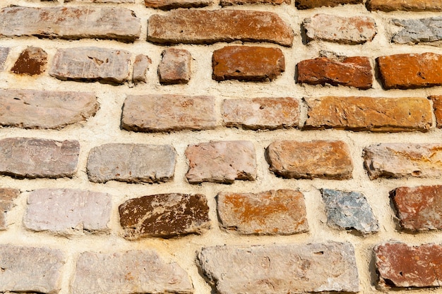 Un vieux mur fait de briques de différents types et tailles, un gros plan d'une partie du mur fait de briques