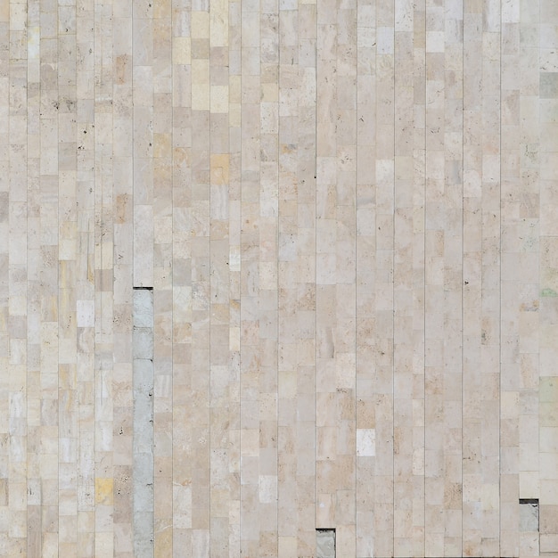 vieux mur de marbre beige fait d'une variété de grandes tuiles