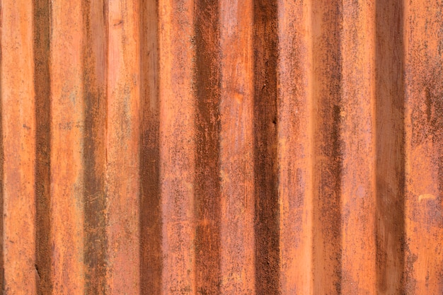 Vieux mur de métal ondulé rouillé à rayures verticales