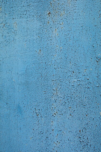 vieux mur peint avec de la peinture bleue qui est fissurée de temps en temps