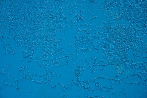 vieux mur peint avec de la peinture bleue qui est fissurée de temps en temps