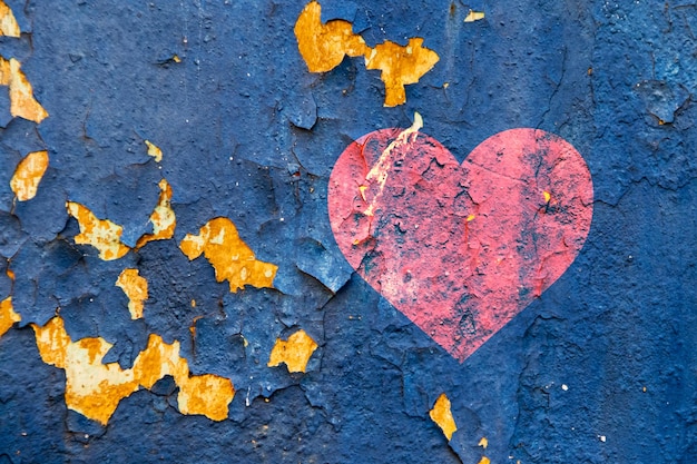 Un vieux mur avec de la peinture qui s'écaille et des coeurs rouges