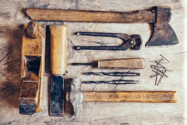 Vieux outils de construction sur un établi en bois plat laïc arrière-plan. Table de menuisier. Boiseries