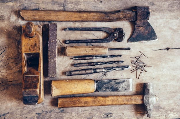 Vieux outils de construction sur un établi en bois plat laïc arrière-plan. Table de menuisier. Boiseries