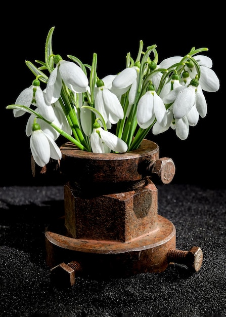 Vieux outils métalliques rouillés et gouttelettes de neige blanches sur un fond noir