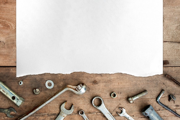 Vieux outils et papier blanc sur fond de plancher en bois