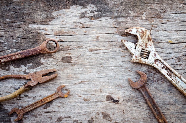 Vieux outils rouillés sur fond de bois ancien. clé sur bois. styles rustiques. vue de dessus