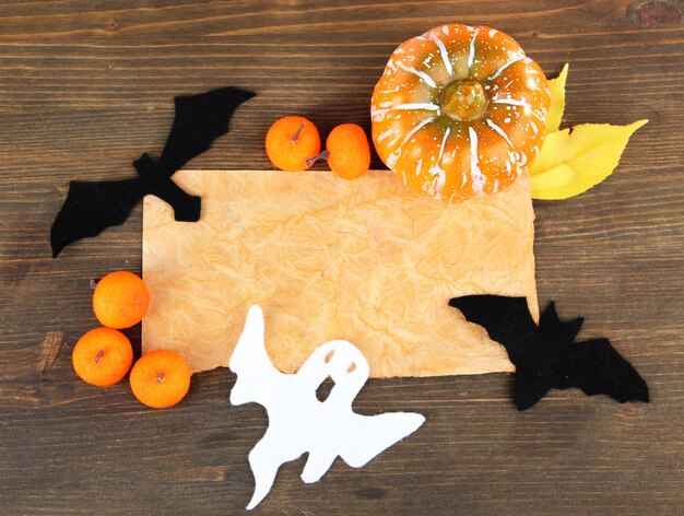 Photo vieux papier avec des décorations d'halloween sur un fond en bois gris