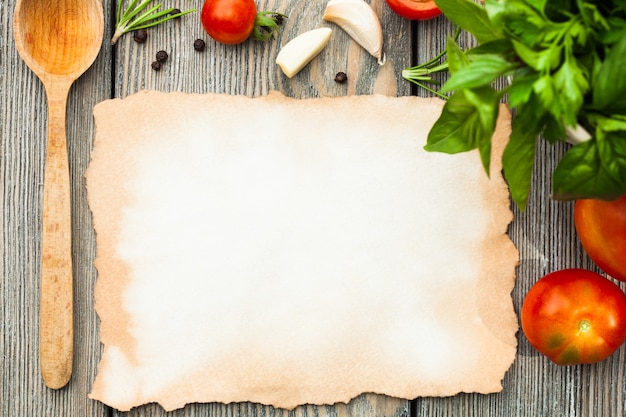 Vieux papier vierge avec espace de copie pour la recette avec ingrédients et cuillère en bois sur la table