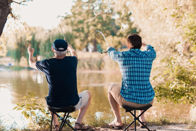 Vieux père avec fils barbu de pêche sur la rivière.