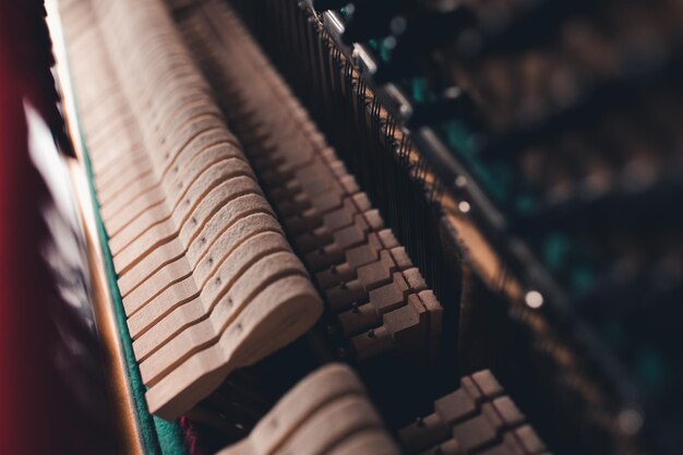 Photo vieux piano acoustique vintage à l'intérieur avec des marteaux et des cordes en gros plan tuning d'un instrument de musique focus sélectif